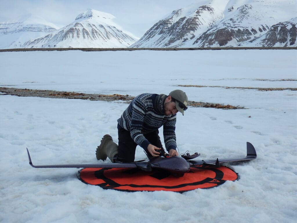 Foto av forsker som bytter batteri på en drone