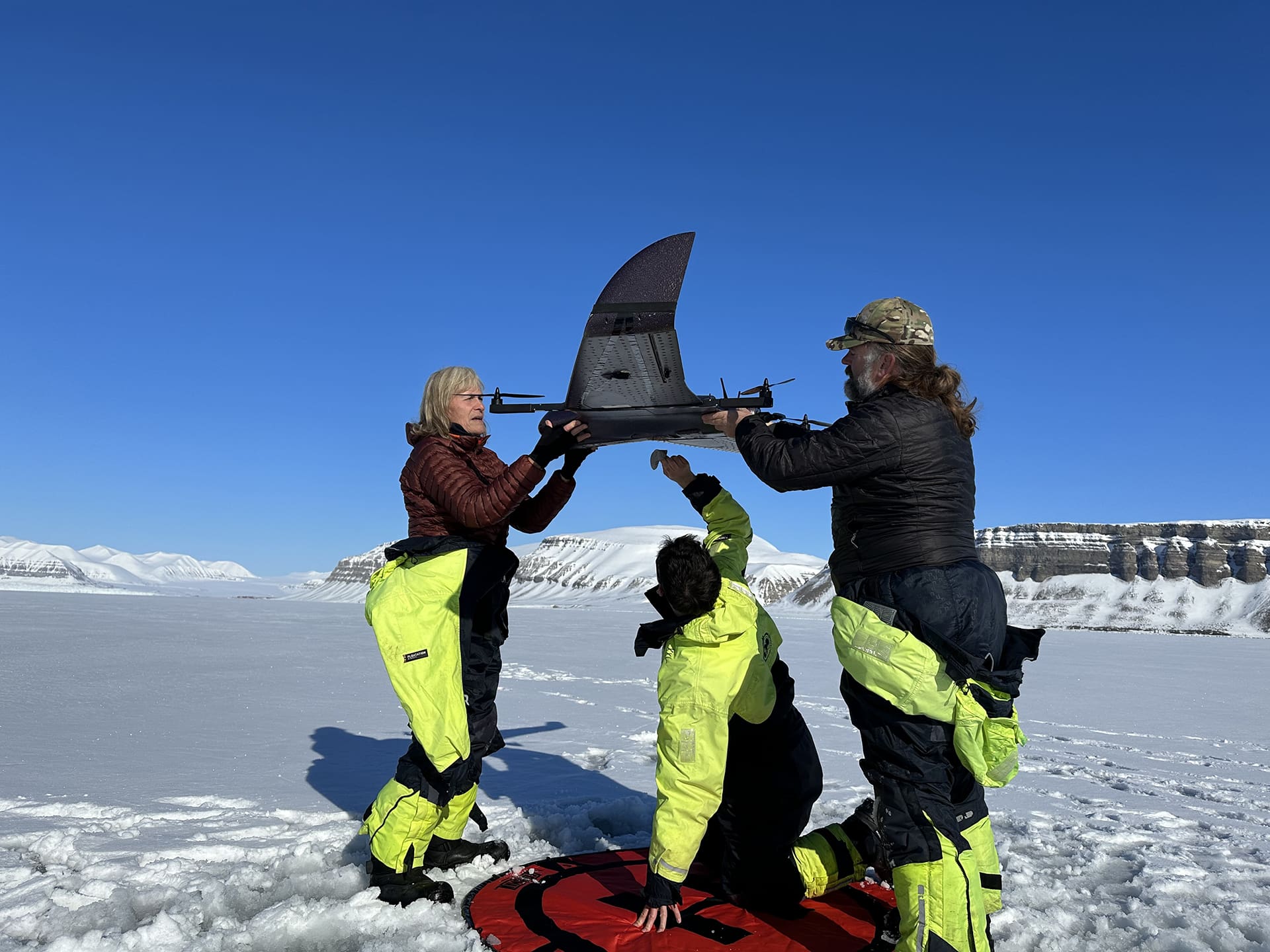Foto av forskere som fjerner snø fra en drone