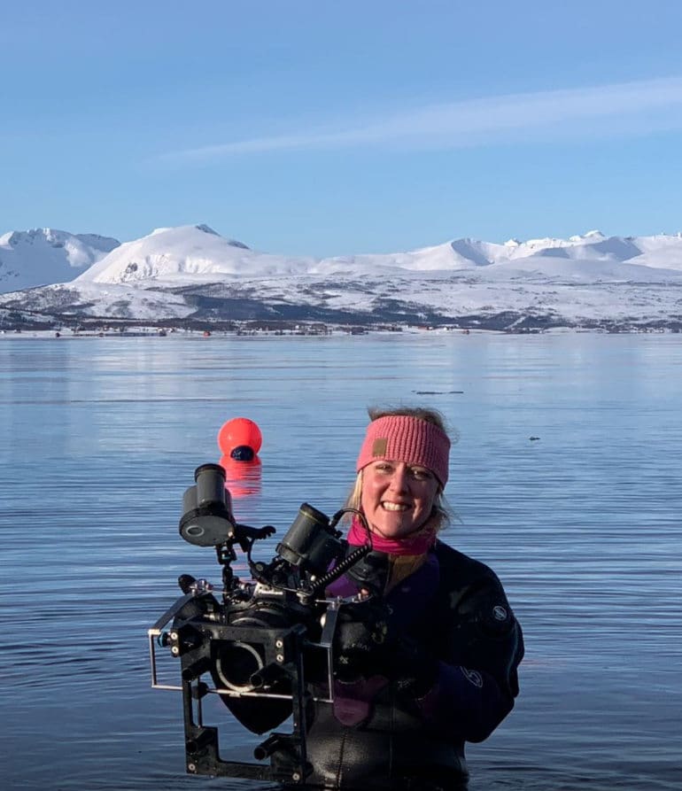 Dr Terri Souster standing with a camera in the water