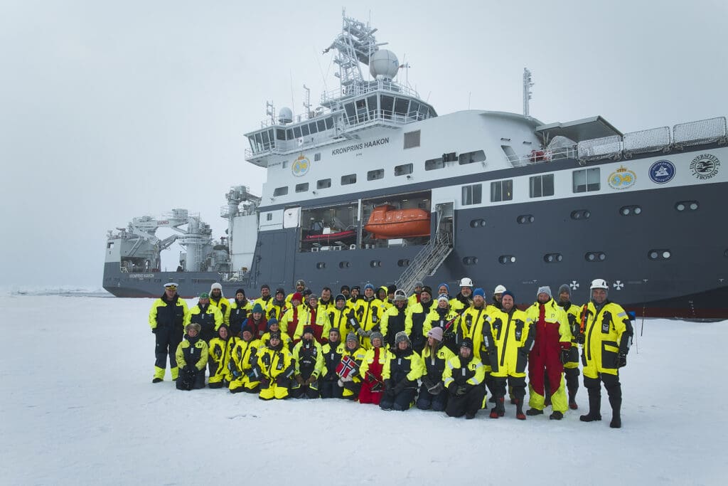 Foto av forskningsteam foran skip